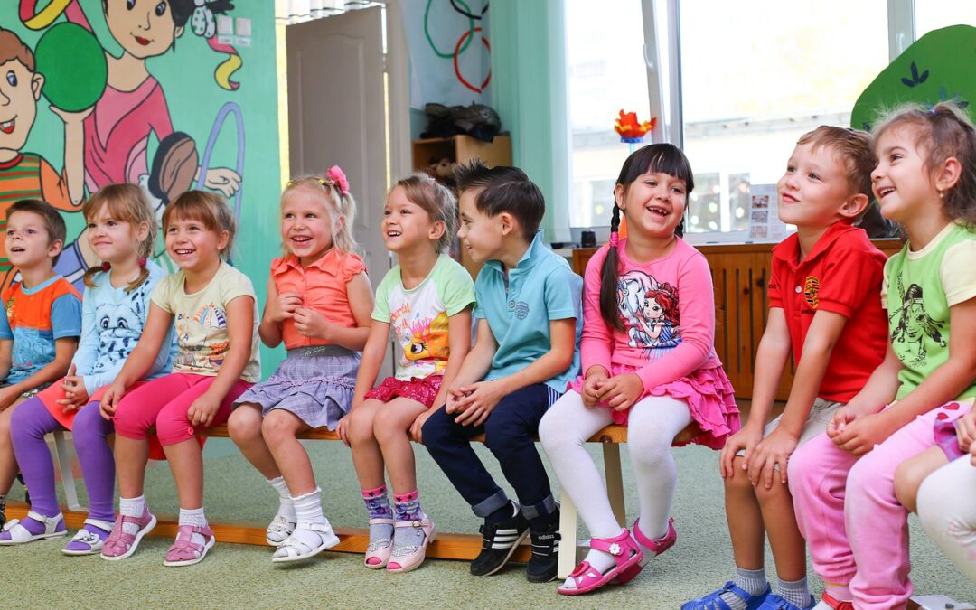 zeigt viele Kinder sitzend auf stühlen